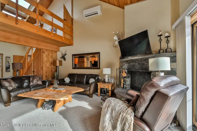 a living room with furniture a flat screen tv and kitchen view