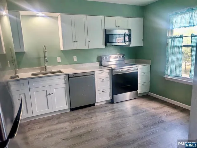 a kitchen with stainless steel appliances a stove sink and cabinets