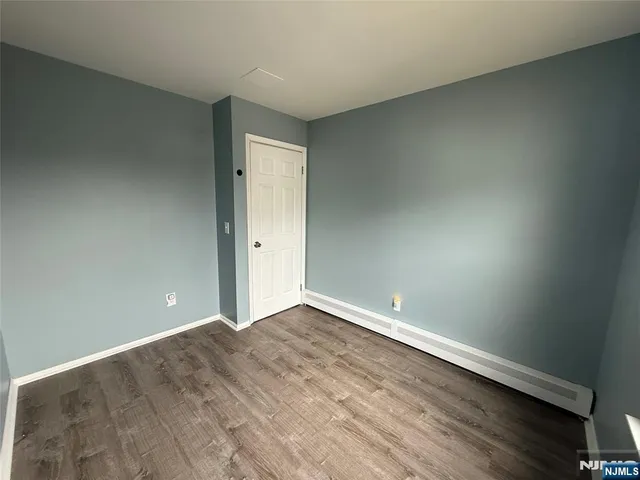 an empty room with wooden floor and entrance
