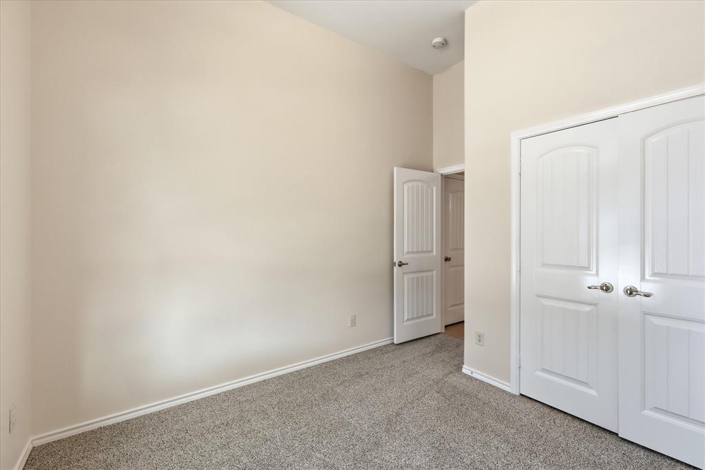 720 Rio Bravo Drive Fort Worth, TX 76052 - Photo 14 of 38 Interior room featuring light neutral wall paint, white trim, and gray speckled carpeting