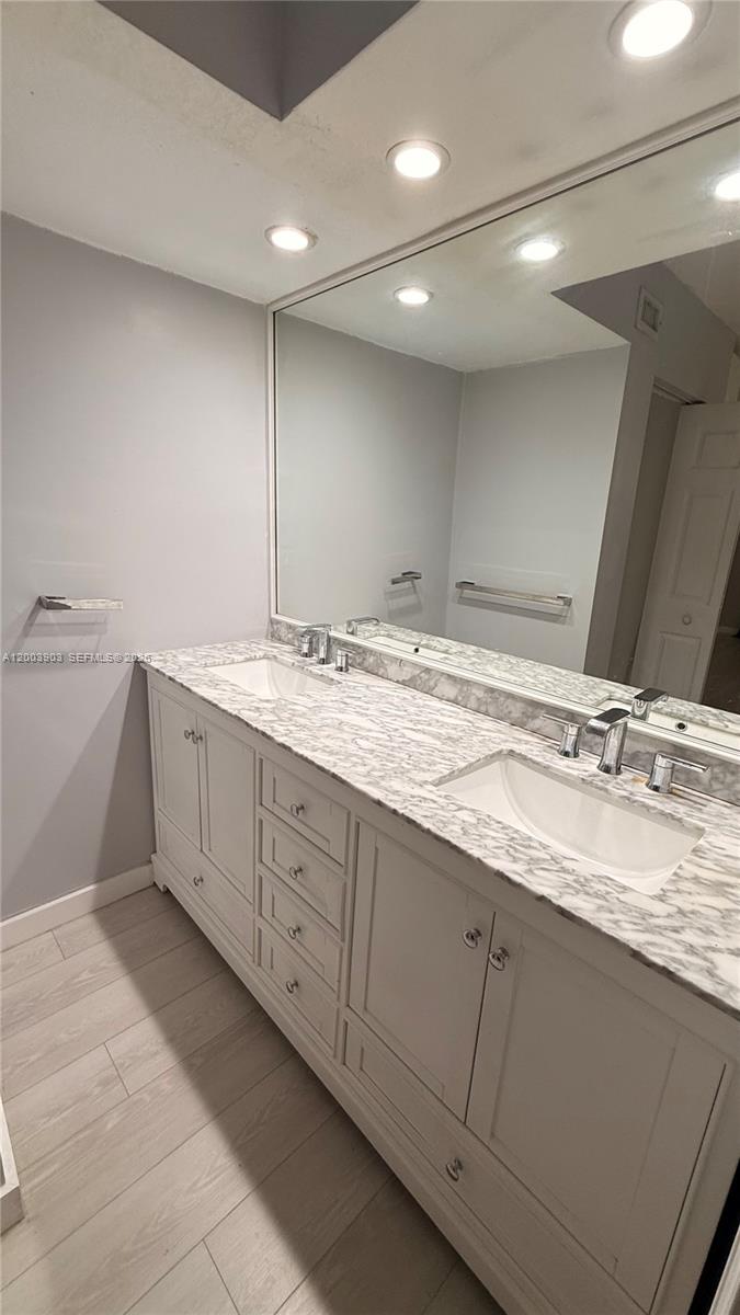 821 Lyons Road, Unit 21102 Coconut Creek, FL 33063 - Photo 9 of 17 a bathroom with a granite countertop sink and a mirror