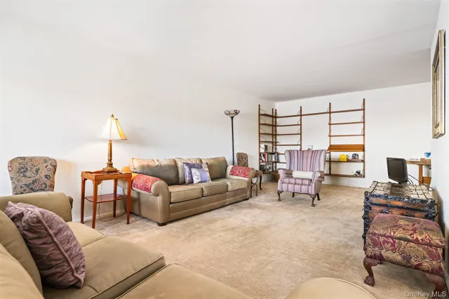 a living room with furniture kitchen view and a window