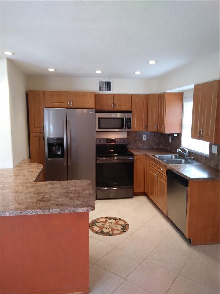 4508 West Park Road Hollywood, FL 33021 - Photo 5 of 13 a kitchen with stainless steel appliances granite countertop a stove a sink a refrigerator and a microwave