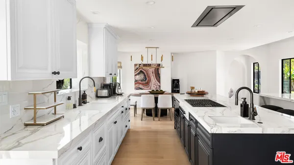 a kitchen with a table chairs refrigerator and cabinets
