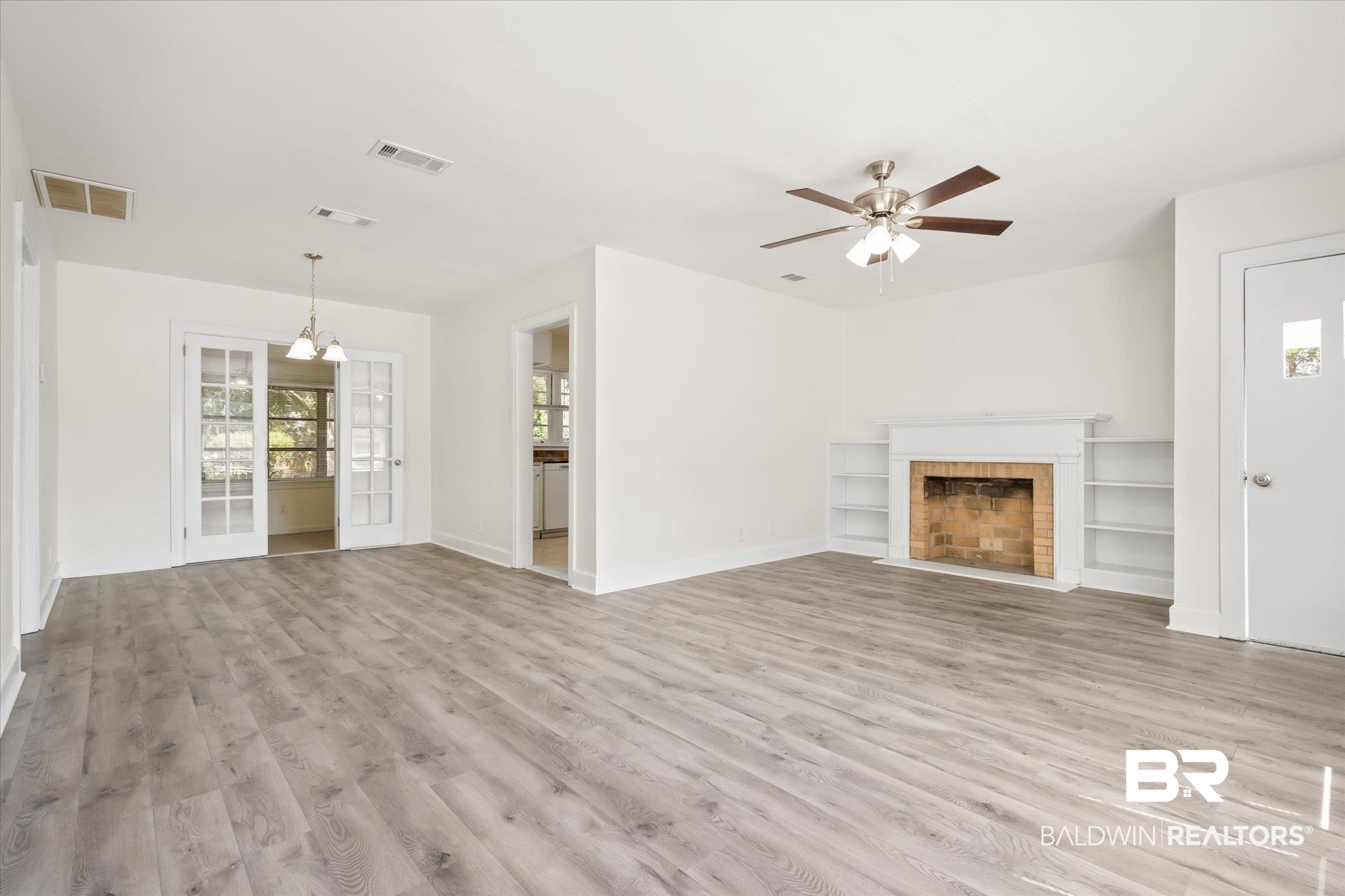 1306 Azalea Street Mobile, AL 36604 - Photo 4 of 20 Unfurnished living room featuring ceiling fan with notable chandelier and light hardwood / wood-style flooring