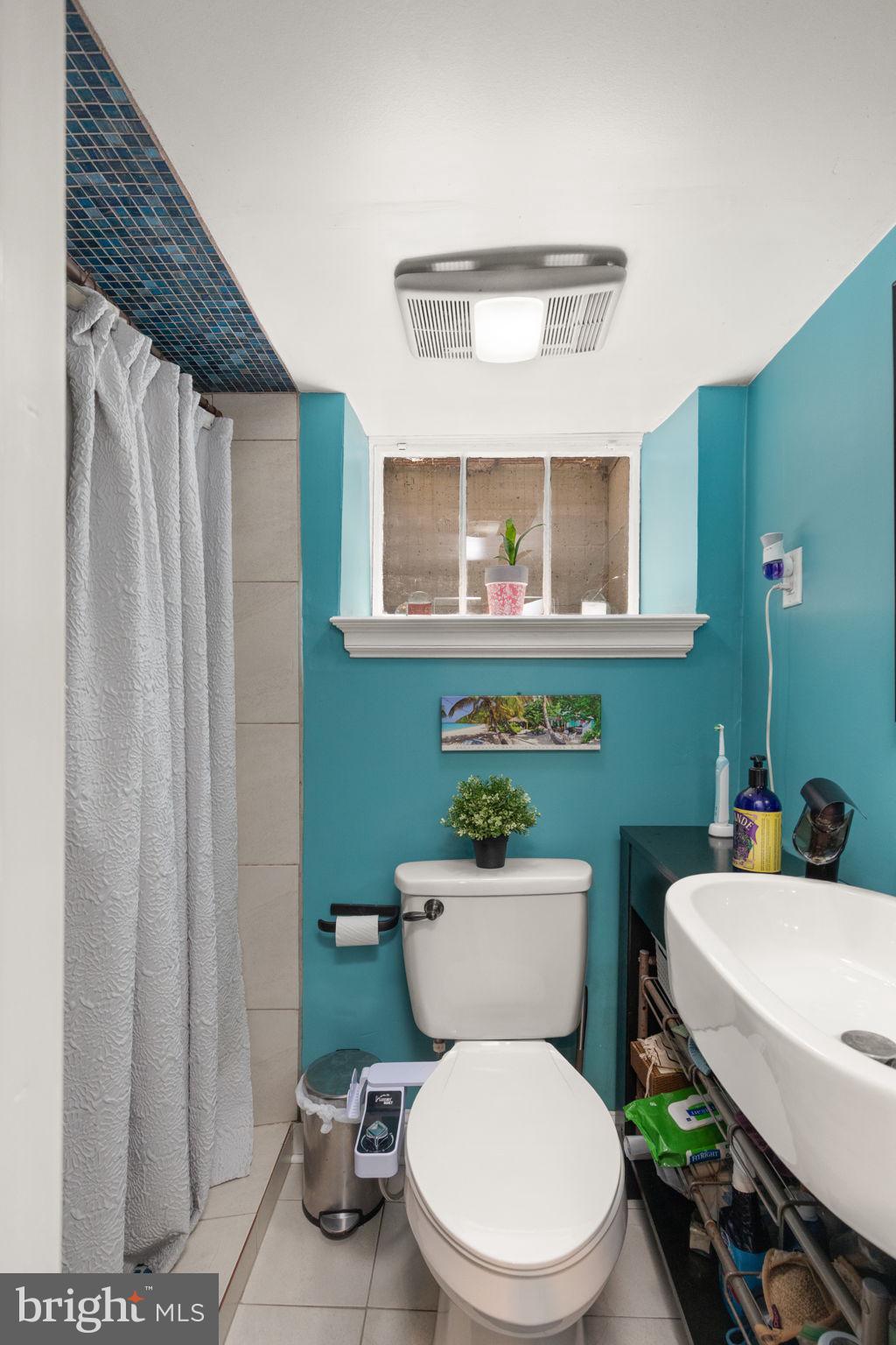 311 Taplow Road Baltimore, MD 21212 - Photo 28 of 32 a bathroom with a toilet a sink and a mirror