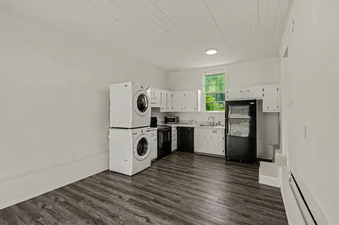 a kitchen with granite countertop white cabinets and white appliances