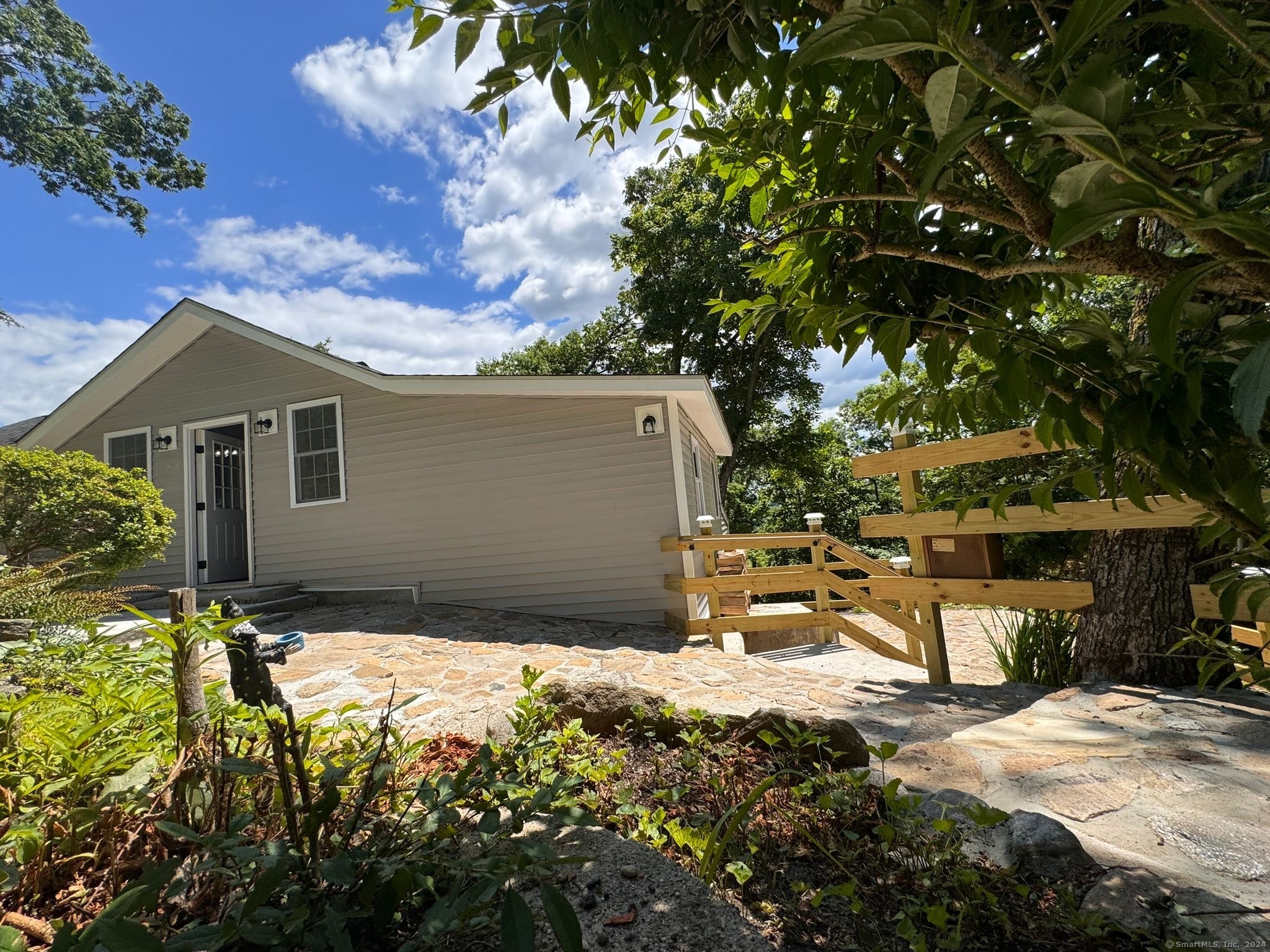 22 Hemlock Trail Newtown, CT 06482 - Photo 3 of 31 a backyard of a house with table and chairs under an umbrella