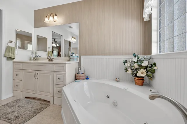 an empty room with windows and ceiling fan