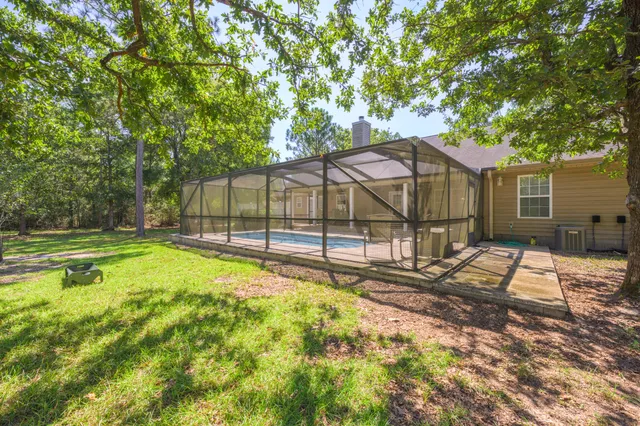 an aerial view of residential house with outdoor space and trees all around