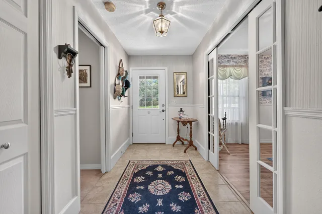 a kitchen with stainless steel appliances granite countertop a stove top oven a sink dishwasher and white cabinets with wooden floor