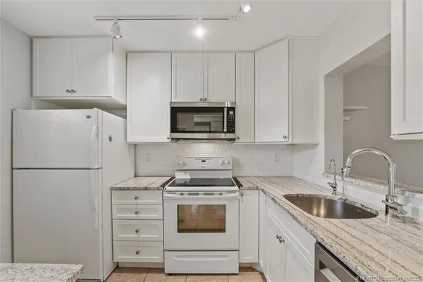 a kitchen with white cabinets sink and white appliances