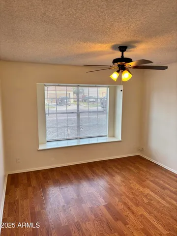 en view of an empty room with a window and wooden floor