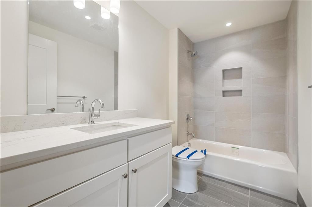 2330 Penn Avenue, Unit 302 Pittsburgh, PA 15222 - Photo 20 of 27 a bathroom with a toilet a bath tub a sink and mirror