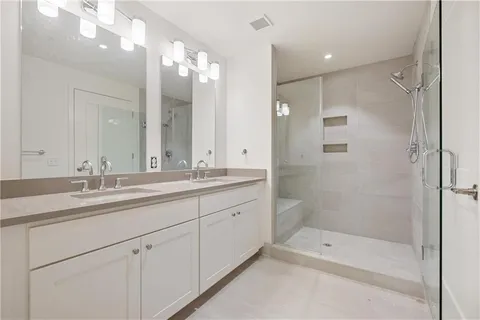 a bathroom with a shower tub double vanity sink and mirror