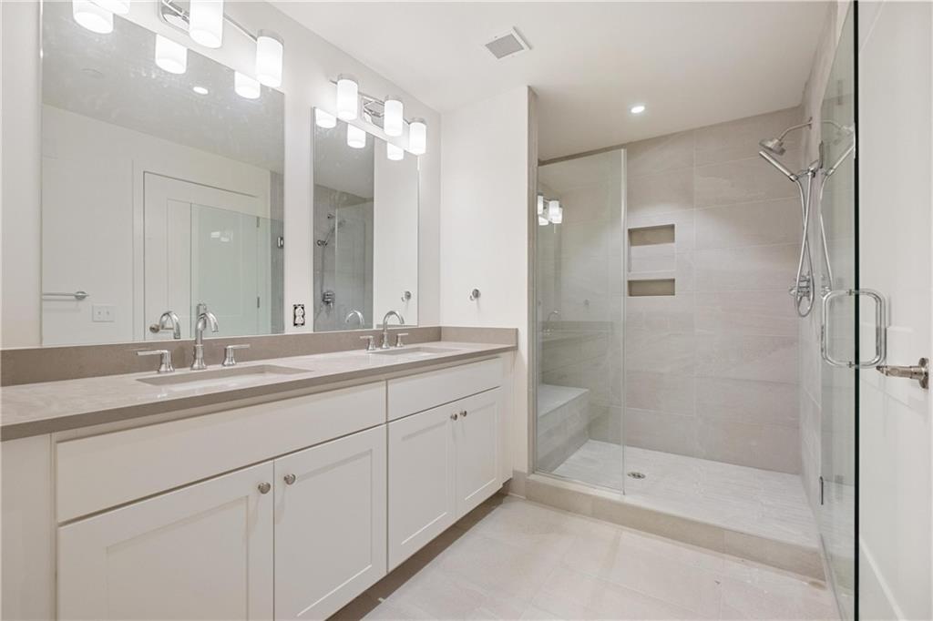 2330 Penn Avenue, Unit 302 Pittsburgh, PA 15222 - Photo 23 of 27 a bathroom with a shower tub double vanity sink and mirror