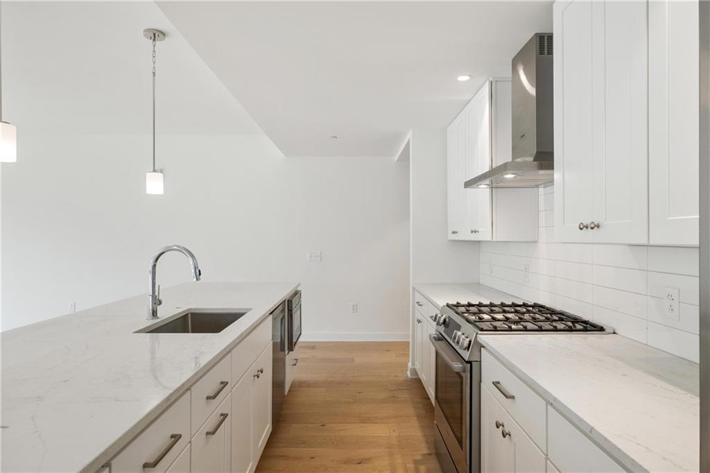 2330 Penn Avenue, Unit 302 Pittsburgh, PA 15222 - Photo 5 of 27 a kitchen with stainless steel appliances a sink a stove and a refrigerator