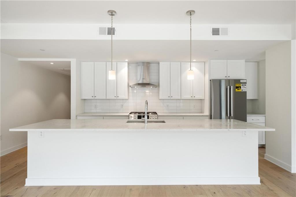 2330 Penn Avenue, Unit 302 Pittsburgh, PA 15222 - Photo 6 of 27 a kitchen with kitchen island a counter top space appliances and a cabinets