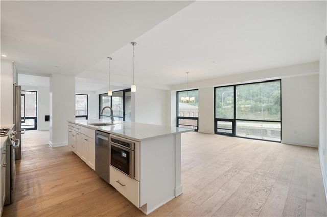 a large kitchen with stainless steel appliances granite countertop a stove and a sink