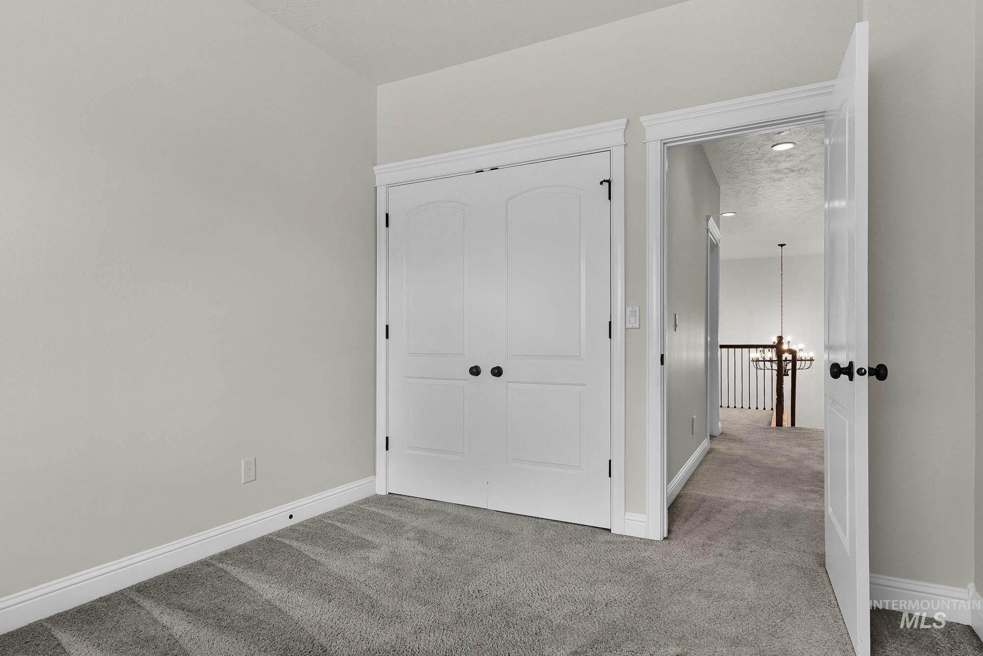 2172 West Cedar Grove Street Meridian, ID 83646 - Photo 34 of 49 Room featuring neutral wall paint, gray carpet flooring, white baseboards, and white trim around doors