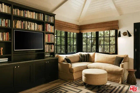 a living room with furniture wooden floor and a book shelf
