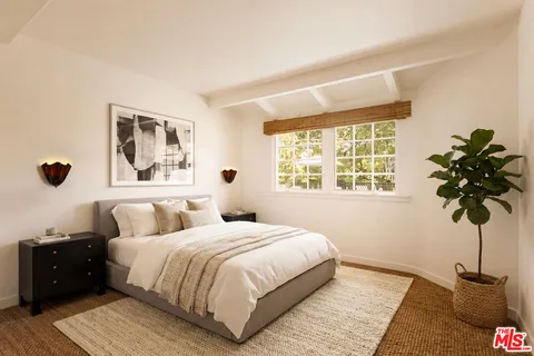 a bedroom with a bed lamp and a potted plant
