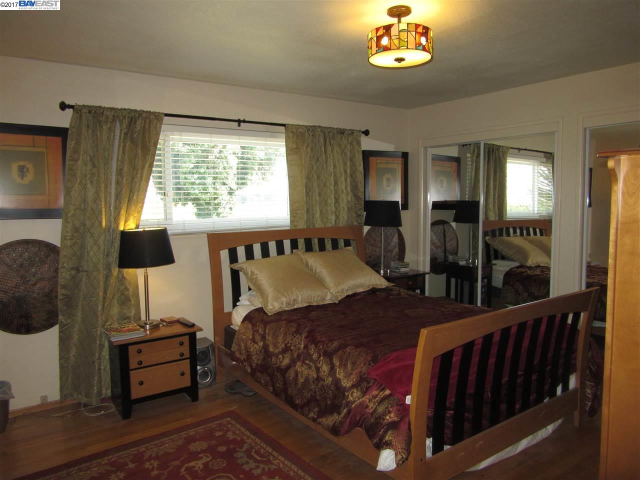 16373 Austin Road Manteca, CA 95336 - Photo 7 of 16 a bedroom with a bed and a chandelier