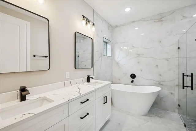 a bathroom with a double vanity sink mirror and bathtub