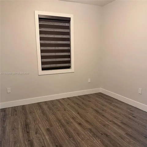 an empty room with wooden floor and closet