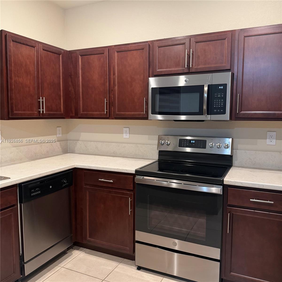 10320 West 33rd Lane Hialeah, FL 33018 - Photo 5 of 29 a kitchen with wooden cabinets and stainless steel appliances