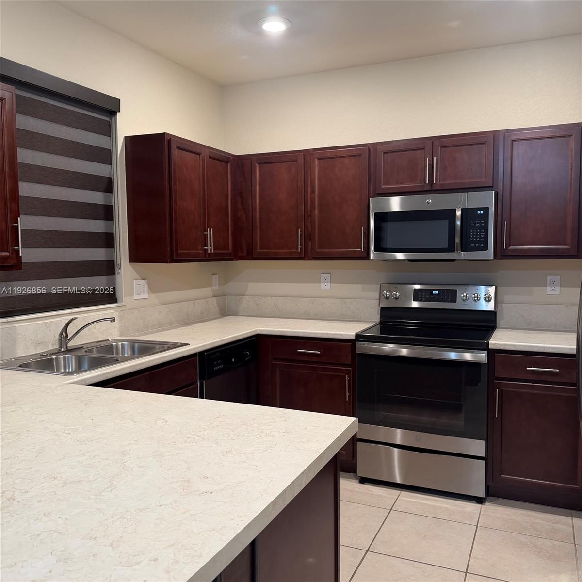 10320 West 33rd Lane Hialeah, FL 33018 - Photo 6 of 29 a kitchen with a sink and a stove top oven