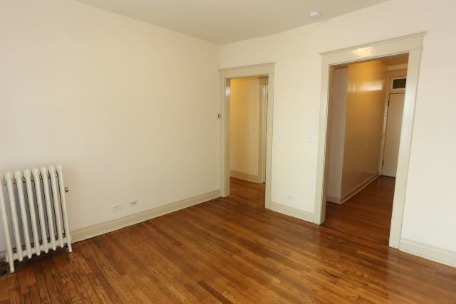 4716 North Racine Avenue, Unit 2E Chicago, IL 60640 - Photo 6 of 19 an empty room with wooden floor and closet