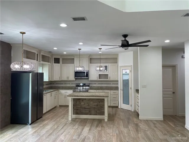 a kitchen with stainless steel appliances a stove a refrigerator and a refrigerator