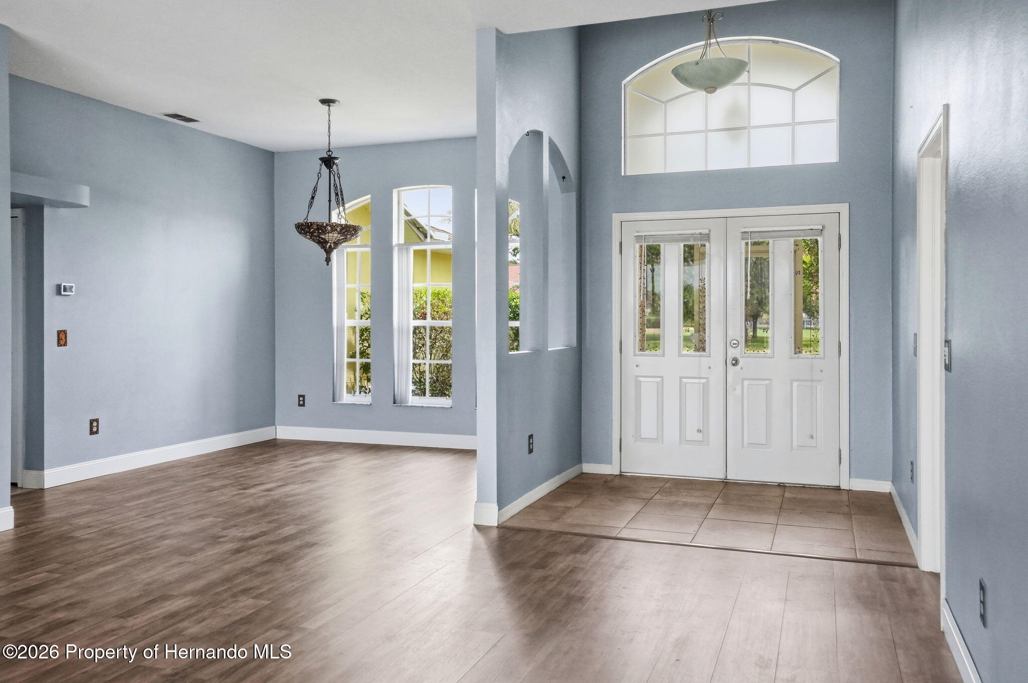 18131 Rivard Boulevard Brooksville, FL 34604 - Photo 5 of 66 an empty room with wooden floor and a window