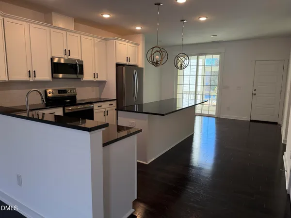 a kitchen with stainless steel appliances granite countertop a stove a sink a refrigerator and a microwave