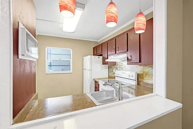 a view of an empty room with wooden floor and windows