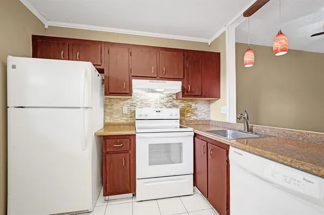 a kitchen with stainless steel appliances granite countertop a refrigerator sink stove and cabinets