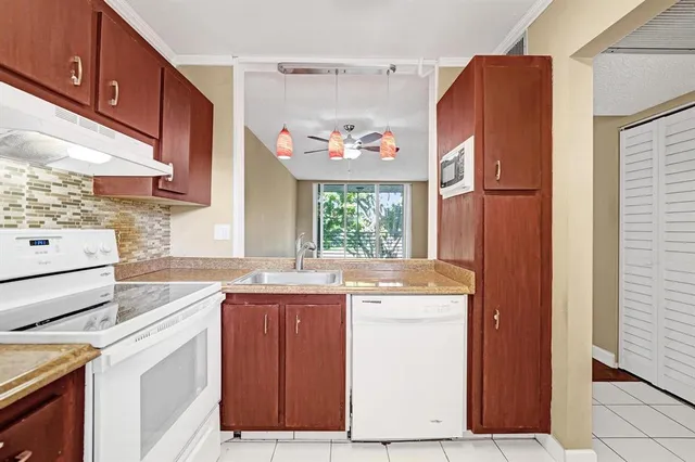 a kitchen with a sink a stove a refrigerator and cabinets