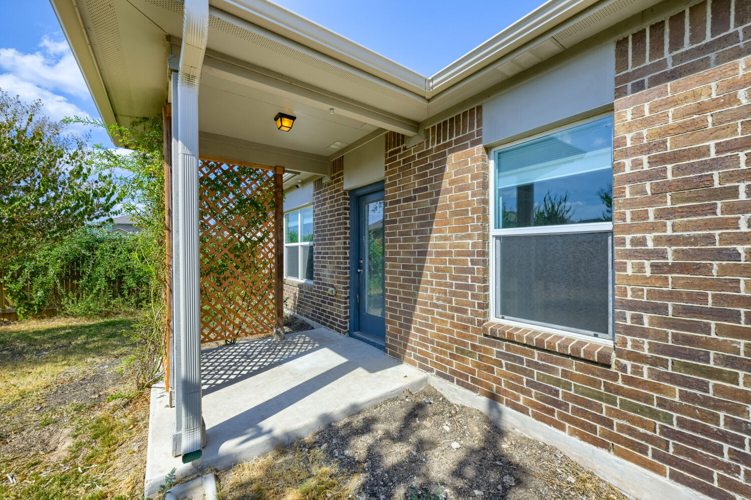 109 Moravia Road Georgetown, TX 78626 - Photo 25 of 25 A concrete back porch rests under a covered roof alongside classic brick siding.