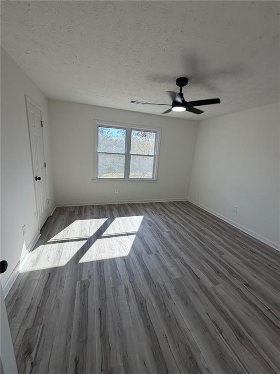 2250 Kings Gate Circle Southwest, Unit B Snellville, GA 30078 - Photo 18 of 31 an empty room with wooden floor chandelier fan and windows