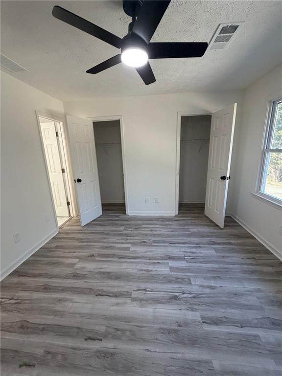2250 Kings Gate Circle Southwest, Unit B Snellville, GA 30078 - Photo 21 of 31 an empty room with wooden floor fan and windows