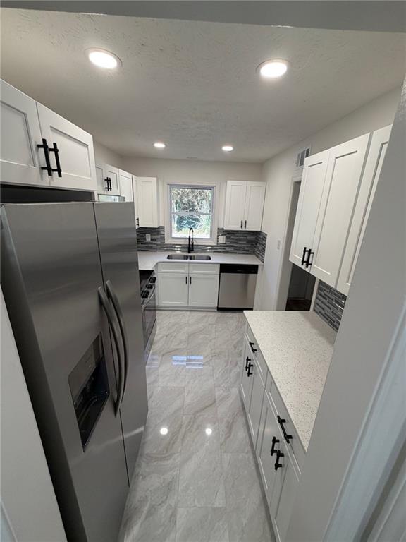 2250 Kings Gate Circle Southwest, Unit B Snellville, GA 30078 - Photo 5 of 31 a kitchen with a sink a refrigerator and cabinets