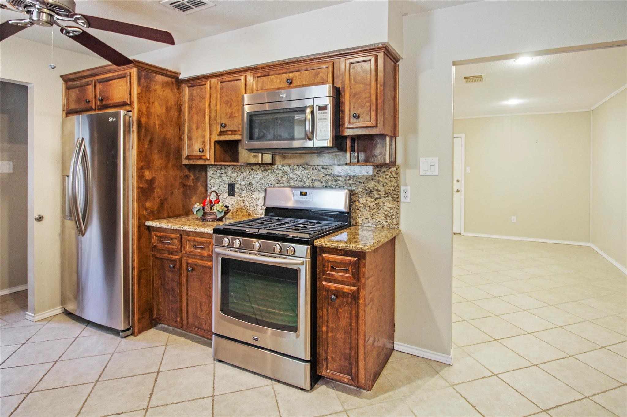 1915 East Allegro Street Houston, TX 77080 - Photo 4 of 13 a kitchen with stainless steel appliances granite countertop a refrigerator and a stove