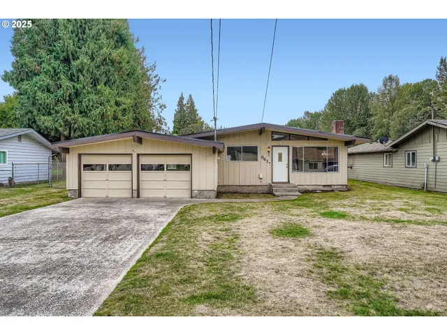 a view of a house with backyard and wooden fence