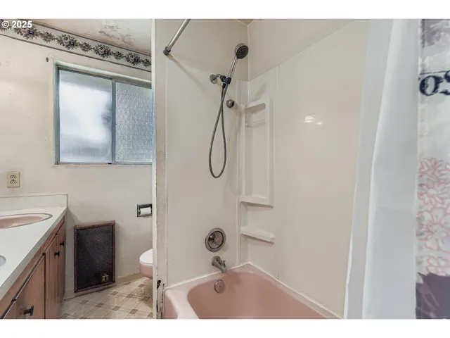 a bathroom with a granite countertop sink a mirror and shower