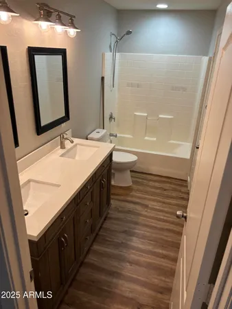 a spacious bathroom with a double vanity sink a mirror and a bathtub