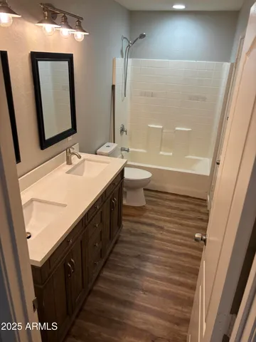 a spacious bathroom with a double vanity sink a mirror and a bathtub