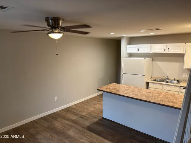 a room with kitchen island a wooden floor and window