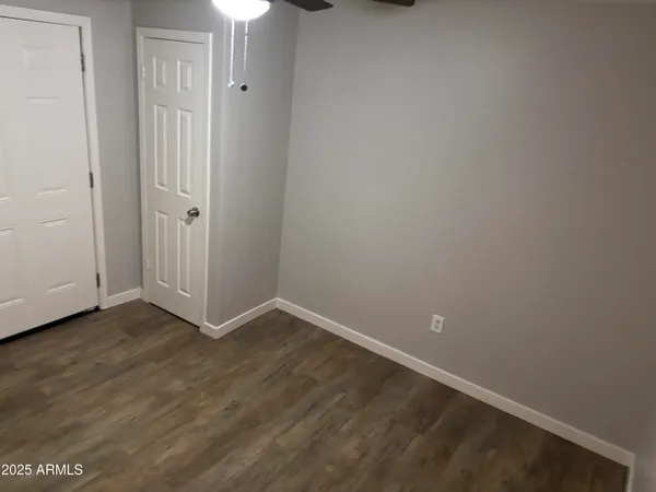 a view of an empty room with closet and a window
