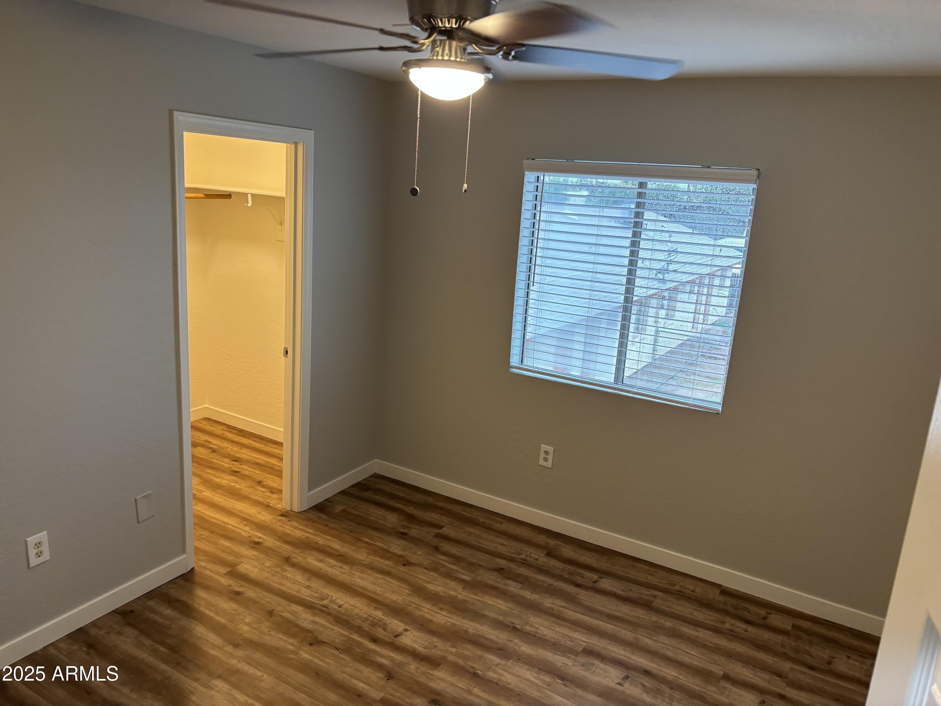 528 East Navajo Avenue, Unit 3 Apache Junction, AZ 85119 - Photo 7 of 14 a view of an empty room with wooden floor and a window